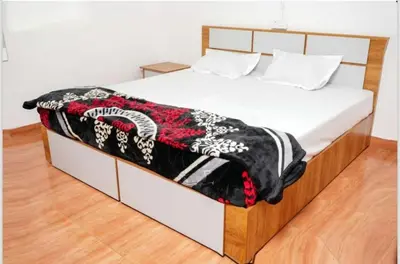 a bed with a black and white blanket on it at Cardamom Garden Homestay Meppadi Wayanad in Meppādi