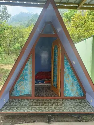 a frame house with a window and a door at Croods cabin in Kodaikānāl