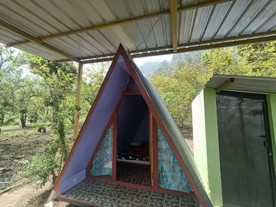 a small house with a large door in the middle at Croods cabin in Kodaikānāl
