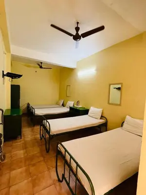 a room with four beds and a ceiling at City Centre in Coimbatore