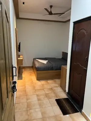 a small bedroom with a bed and a door at City Centre in Coimbatore