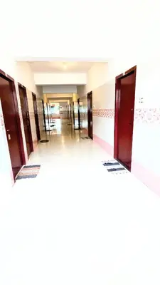 a hallway with many doors in a building at PALLIYARAI GARDENS LODGE AND HOMESTAy in Palani