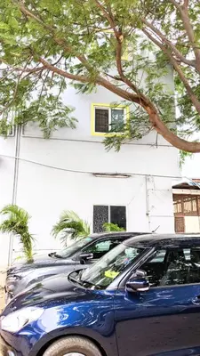 two parked cars parked in front of a building at PALLIYARAI GARDENS LODGE AND HOMESTAy in Palani