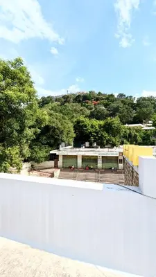 a view of a building from the top of a white wall at PALLIYARAI GARDENS LODGE AND HOMESTAy in Palani