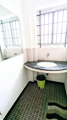 a bathroom with a sink and a tub and a mirror at PALLIYARAI GARDENS LODGE AND HOMESTAy in Palani