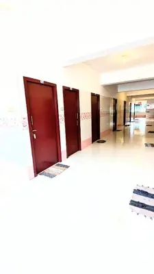 a row of brown doors in a hallway at PALLIYARAI GARDENS LODGE AND HOMESTAy in Palani