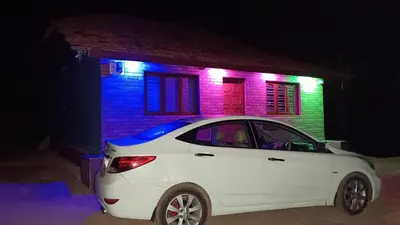 a white car parked in front of a house at night at Ammavvana Kutira Home stay in Madikeri