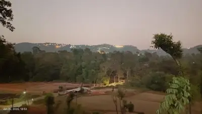 a view of a field with trees in the background at Ammavvana Kutira Home stay in Madikeri