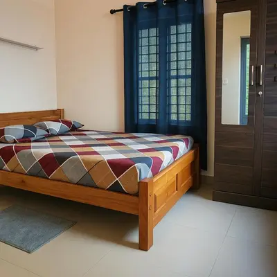 a bedroom with a bed and a window and a door at Coffee View Holiday Homes in Thirunelli