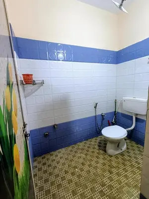 a bathroom with a toilet and blue and white tiles at Coffee View Holiday Homes in Thirunelli
