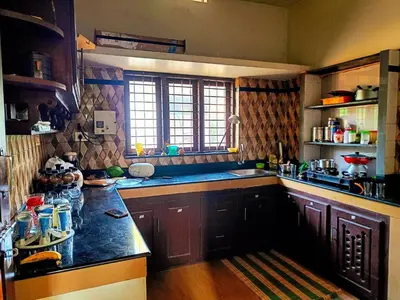 a kitchen with wooden cabinets and a counter top at Coffee View Holiday Homes in Thirunelli