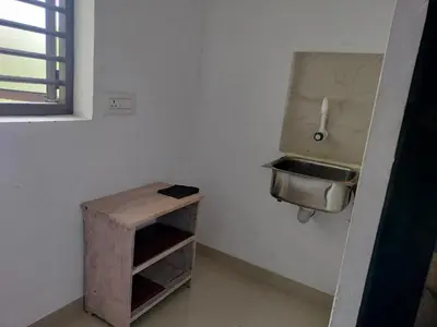 a small kitchen with a sink and a wooden table at Aswathy Bhavan in Vadakkāncheri