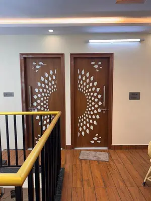 two wooden doors in a room with a staircase at G3 nest in Mysore
