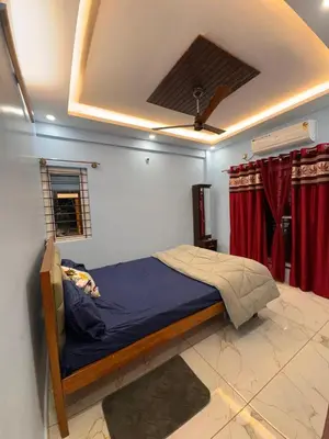 a bedroom with a bed in a room with red curtains at G3 nest in Mysore