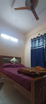 a bedroom with a bed with a ceiling fan at G3 nest in Mysore
