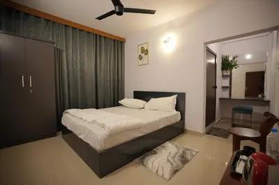a small bedroom with a bed and a mirror at Hotel Le Marina Residency in Kozhikode