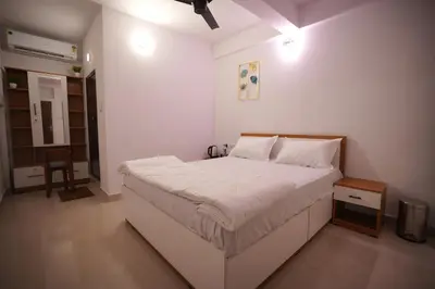 a bedroom with a large white bed in a room at Hotel Le Marina Residency in Kozhikode