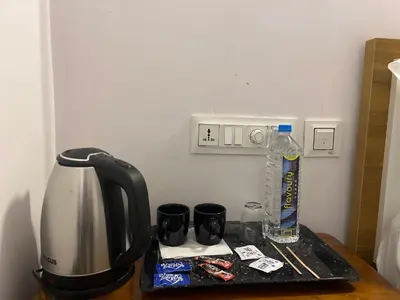 a counter with a coffee maker and cups on it at Hotel Le Marina Residency in Kozhikode