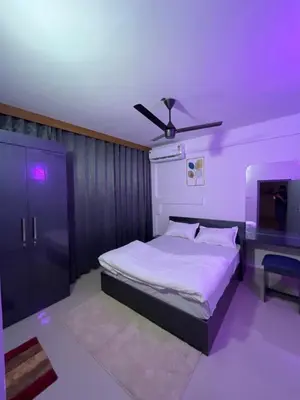 a bedroom with a bed and a ceiling fan at Hotel Le Marina Residency in Kozhikode