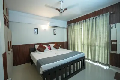 a bedroom with a bed with a ceiling fan and a window at Sancta Maria Lounge -cochin Airport in Nedumbassery