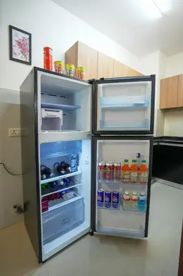 a refrigerator with its door open in a kitchen at Sancta Maria Lounge -cochin Airport in Nedumbassery