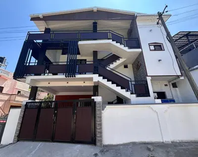 a house with a balcony and a gate at Franklin's Finestay in Kotagiri