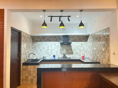 a kitchen with a sink and some lights at Franklin's Finestay in Kotagiri