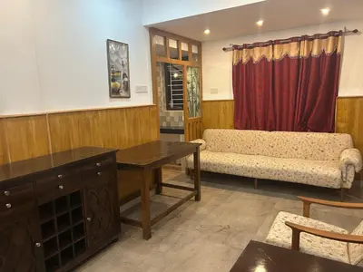 a living room with a couch and a table at Franklin's Finestay in Kotagiri