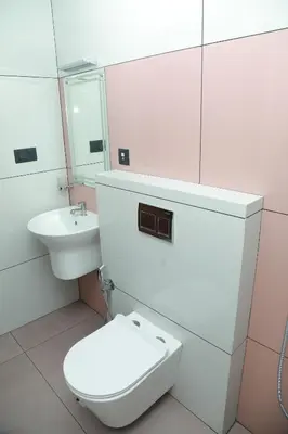 a white bathroom with a toilet and a sink at Marina Tower & Regency Changaramkulam in Edappāl