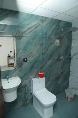 a bathroom with a toilet and a sink at Marina Tower & Regency Changaramkulam in Edappāl
