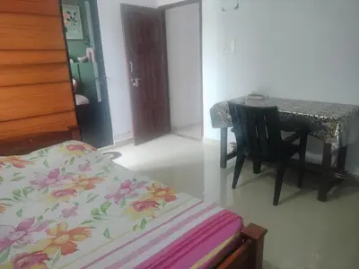 a bedroom with a table and a bed and a table and chair at Aswathy Bhavan in Vadakkāncheri