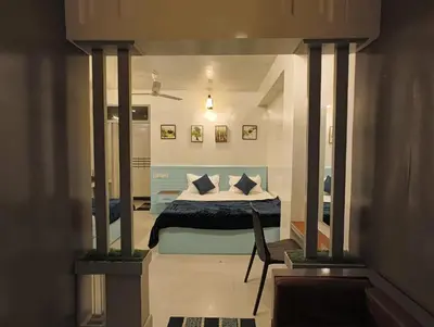 a bedroom with a bed with blue and white pillows at Cocoa Tree Munnar in Munnar