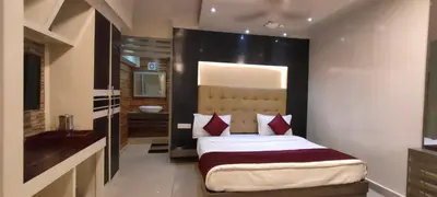 a bedroom with a large bed with red pillows at Cocoa Tree Munnar in Munnar