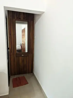 a hallway with a door and a mirror at Milu Homes in Thirunelli