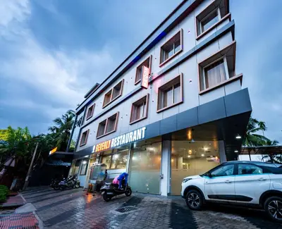 a white car parked in front of a building at Hotel Beverly Palace Kozhikode - Hotel and Restaurant in Kozhikode