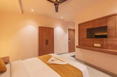 a bedroom with a bed and a flat screen tv at Hotel Beverly Palace Kozhikode - Hotel and Restaurant in Kozhikode
