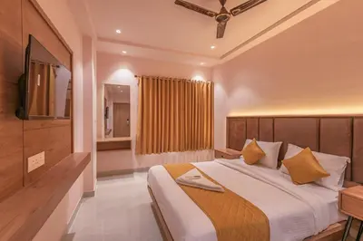 a bedroom with a large bed and a television at Hotel Beverly Palace Kozhikode - Hotel and Restaurant in Kozhikode