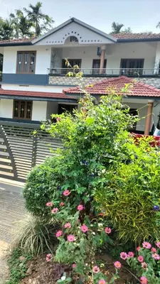 a house with pink flowers in front of it at VELLAKUZHY Homestay Wayanad in Wayanad