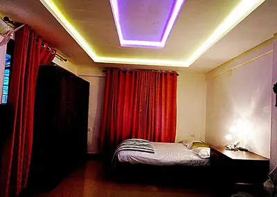 a bedroom with a bed and a light on the ceiling at Natura Homestay in Padinjarathara