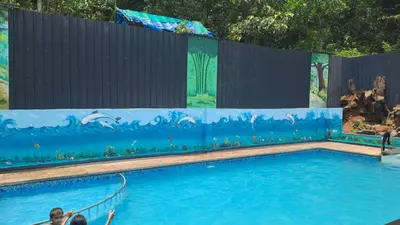 a large swimming pool with a painting on the wall at Natura Homestay in Padinjarathara