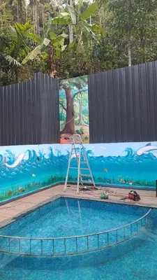 a pool with a ladder in the middle of a mural at Natura Homestay in Padinjarathara