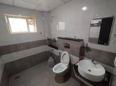 a bathroom with a toilet and a sink at Guruvayoor Suits Pankaj Suits in Trichūr