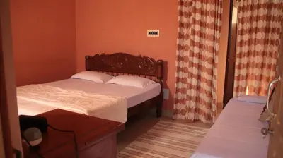 a small bedroom with two beds and curtains at Coorgglade in Kakkabe