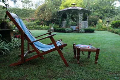 a chair and a table in a yard with a gazebo at The School Estate in 100 Acres in Siddapur
