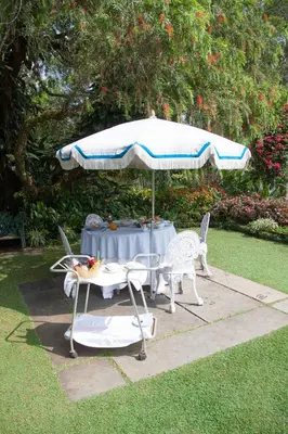 a table with an umbrella and two chairs and a table with at The School Estate in 100 Acres in Siddapur