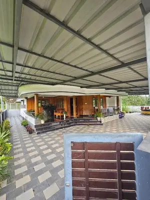 a building with a patio with awning and a gate at Sunset View Inn in Irinjālakuda