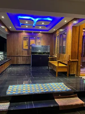 a room with a stage with a piano and a bench at Sunset View Inn in Irinjālakuda