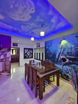 a room with a table with an aquarium on the wall at Sunset View Inn in Irinjālakuda