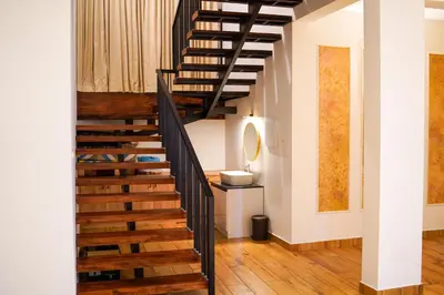 a winding staircase in a home with wooden floors at Fog Land Pool Villa by BMT in Vythiri