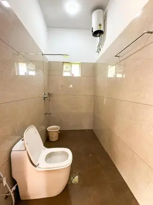 a bathroom with a toilet and a sink at Fog Land Pool Villa by BMT in Vythiri
